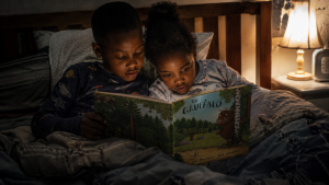 Two black children reading the Gruffalo by Julia Donaldson